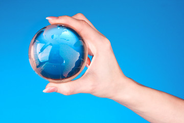Crystal ball on hand. blue background