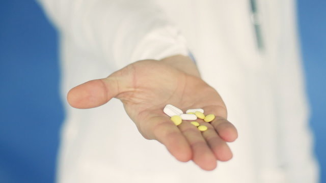 Male doctor hand offering pills