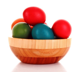 Easter eggs in wooden bowl isolated on white