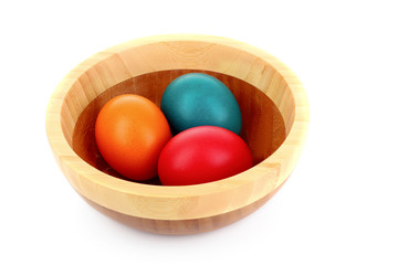 Easter eggs in wooden bowl isolated on white