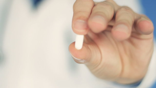Male doctor hand offering pill