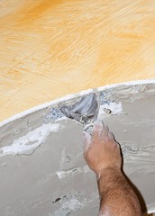 Men at work spreading plaster