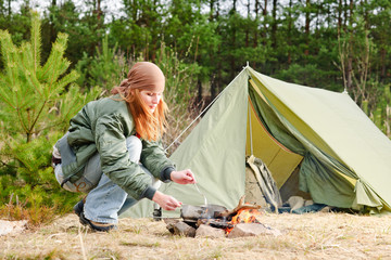 Camping woman tent cook food fire nature