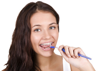 happy girl with braces brushing her teeth