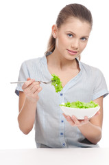 Pretty young woman eating lettuce salad. Isolated