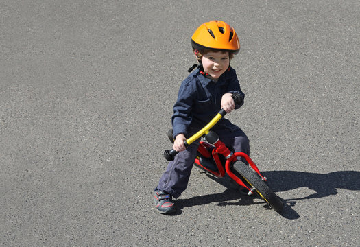 Junge spielt mit seinem Laufrad