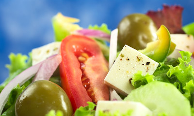 Greek salad with cheese, green olives, tomato, onion, cucumber