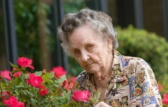 Elderly Woman Smelling Flowers