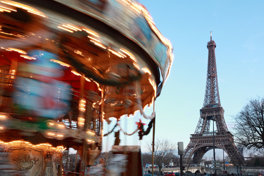Vintage carousel with horses spins, Eiffel tower in Paris