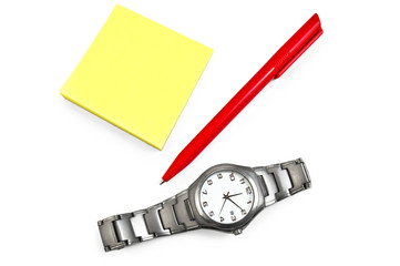 Yellow paper with a red pen, wristwatch