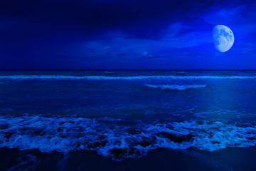 Scène de nuit sur une plage déserte avec un croissant de lune