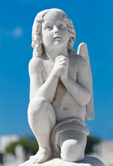 Praying infant angel with a blue sky background