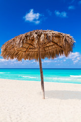 Thatched umbrella on a sandy tropical beach