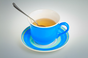 Blue tea cup with a spoon on a plate