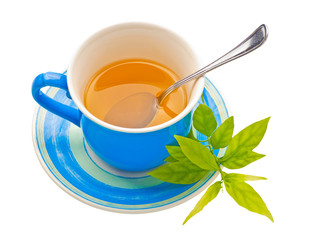 View from above of a blue tea cup and green leaves isolated on a
