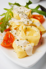 Tortellini pasta with cheese sauce and tomato