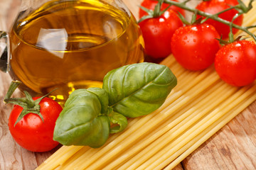 pasta, olive oil and tomatoes on the wood background