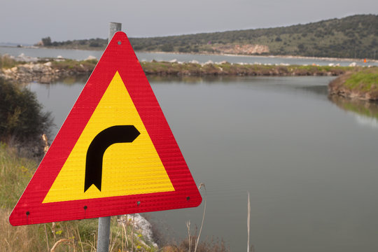 Strange traffic sign pointing right towards a water canal