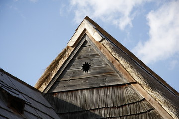 Fototapeta na wymiar historic wooden rooftop with sun symbol