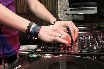 Mains de dj en boite de nuit aux platines 