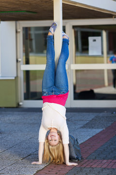 m&auml;dchen macht handstand auf dem schulhof