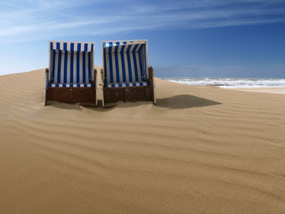 beach chairs on a deserted sand dune