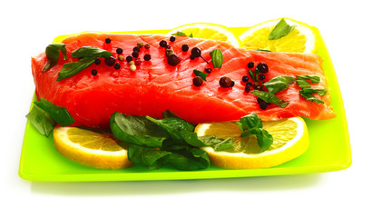 Red fish with pepper and green leaves isolated on white
