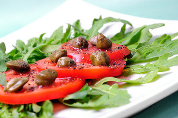 Salad with fresh tomatoes, capers and arugula
