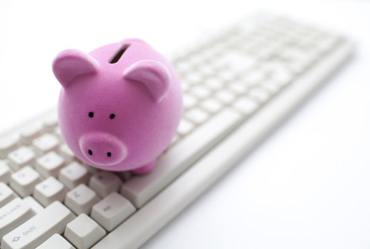 Pink Piggy Bank On Computer Keyboard