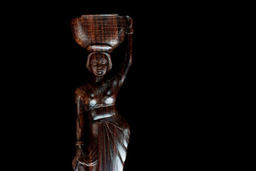 African statue isolated on black background