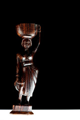 African statue isolated on black background