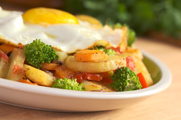 Fried potatoes, tomato, broccoli, onion, carrot and egg