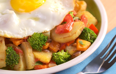 Fried potatoes, tomato, broccoli, onion, carrot, fried egg