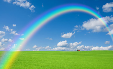 Green grass and red roof house and rainbow