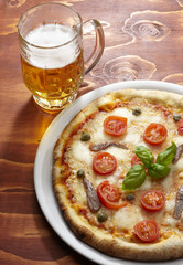 pizza con bicchiere di birra su tavolo di legno