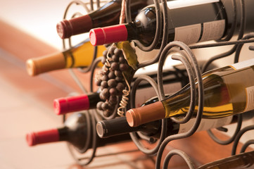 Red and white wine bottles stacked on iron rack