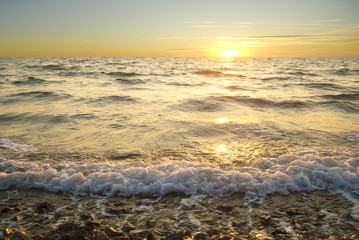 Golden sea sunset with braking waves