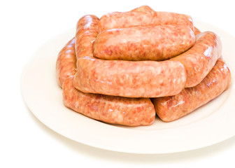 raw sausages in a white plate