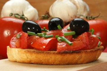 Fototapeta na wymiar geröstetes Tomatenbrot mit Schnittlauch und Oliven