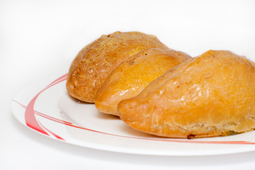 Baked pies on a white plate with red drawing