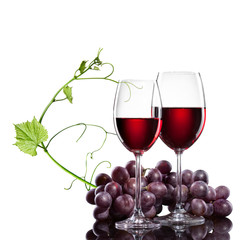 Red wine in glasses with grape and rod isolated on white