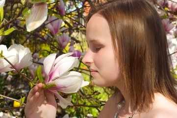 Frau rieht an einer Magnolienbaumblüte