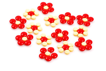 Flower made of red and yellow medicinal pills  on white backgrou
