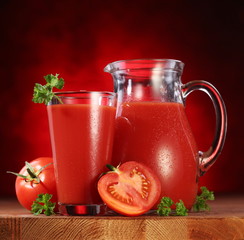 Jug and glass full of tomato juice.