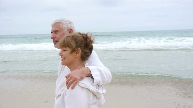 Senior couple walking on spa resort beach