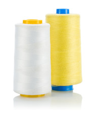 yellow and white thread on spools isolated