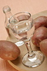 Kartoffelschnaps in einem Glas und eine kleine Flasche