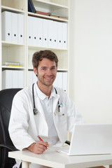 arzt sitzt am schreibtisch