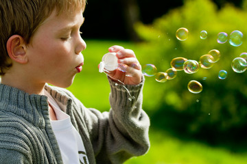 a young child blowing bubbles