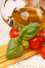 pasta, olive oil and tomatoes on the wood background